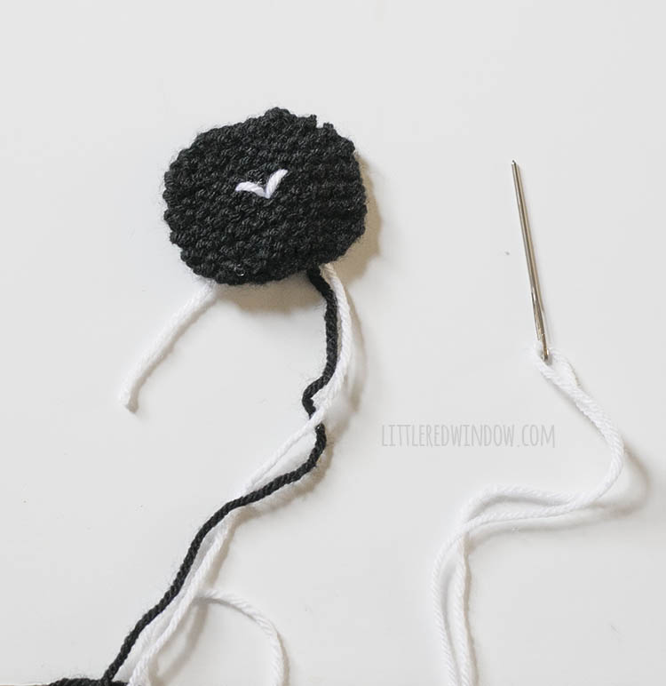 black knit sheep face with white stitches for the nose