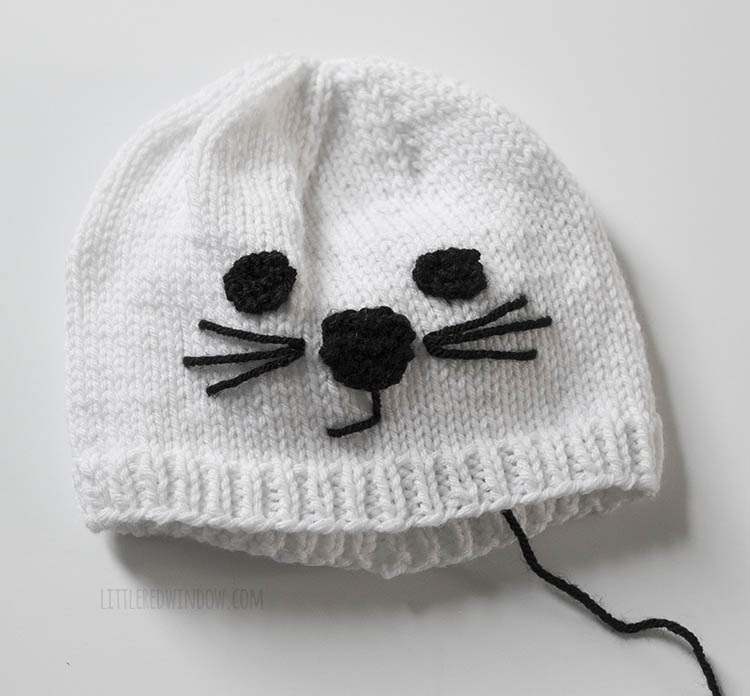 almost finished white seal face on a white knit hat