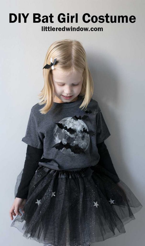 little girl in gray shirt with full moon and bats on it