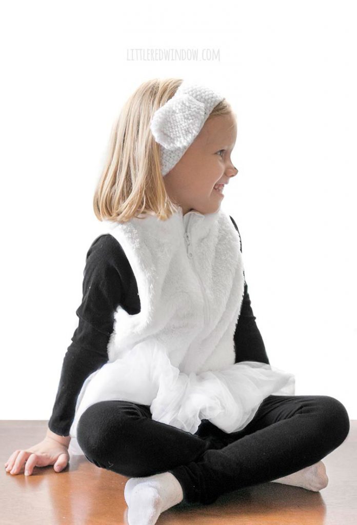 side view of little girl in easy diy sheep costume wearing sheep ears knit headand and looking off to the right