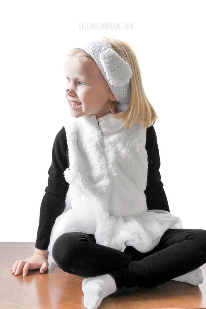 little girl in easy diy sheep costume looking off to the left