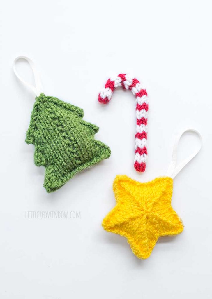 green knit tree red and white knit candy cane and yellow knit star laying flat on a white background
