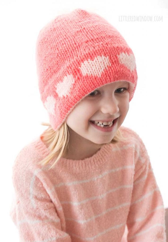 view from slightly above of light pink knit heart pattern around the brim of the double brim heart hat