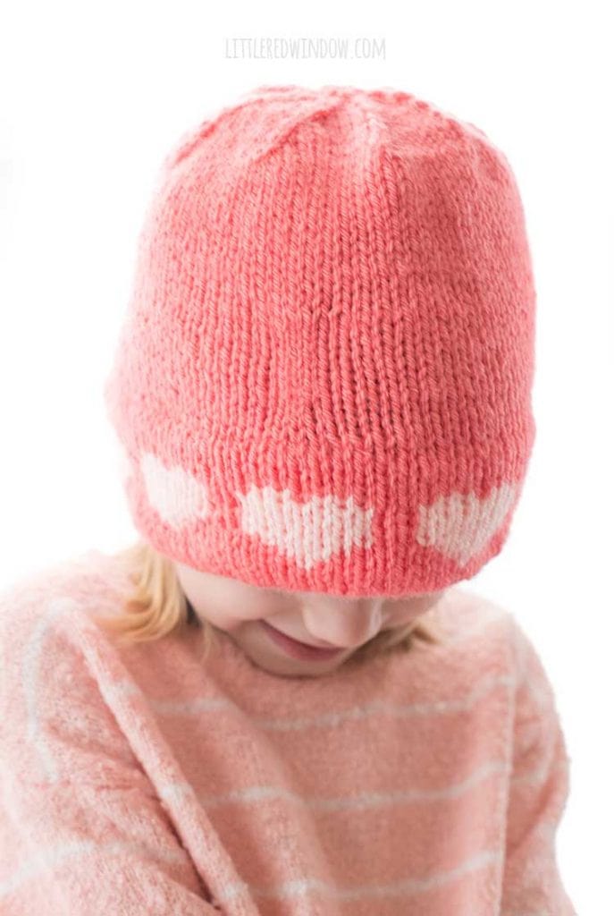 closeup of light pink hearts around the brim of the double brim heart hat knitting pattern