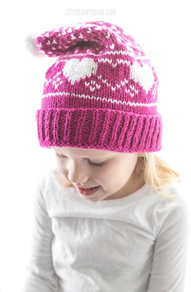 side front view of little girl wearing Valentines Day hear stocking cap