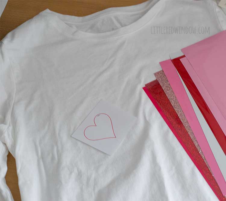 white tshirt with heart shape and sheets of pink and red vinyl on top flatlay