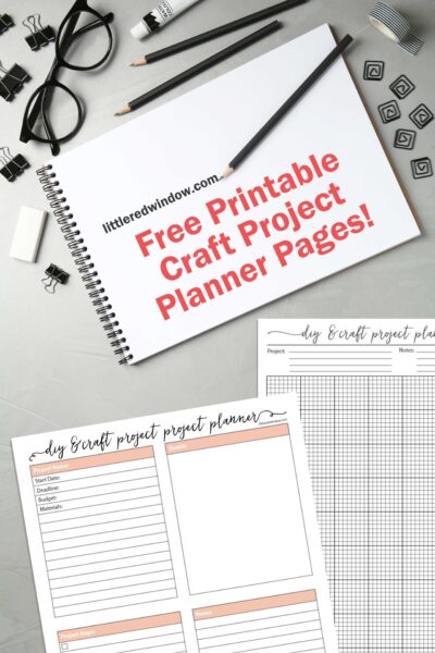office supplies on a gray desk with a white notepad and two sheets of craft project planner pages