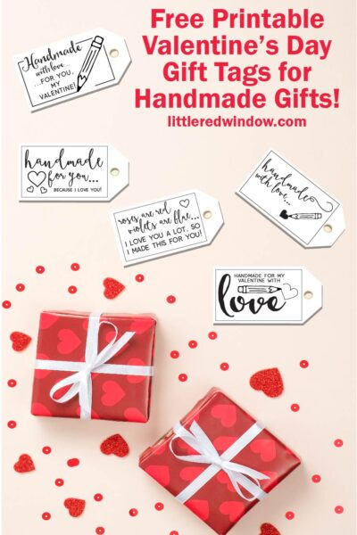 flat lay with light pink background two red presents with heart wrapping paper heart confetti and 5 different valentines day gift tags for handmade gifts