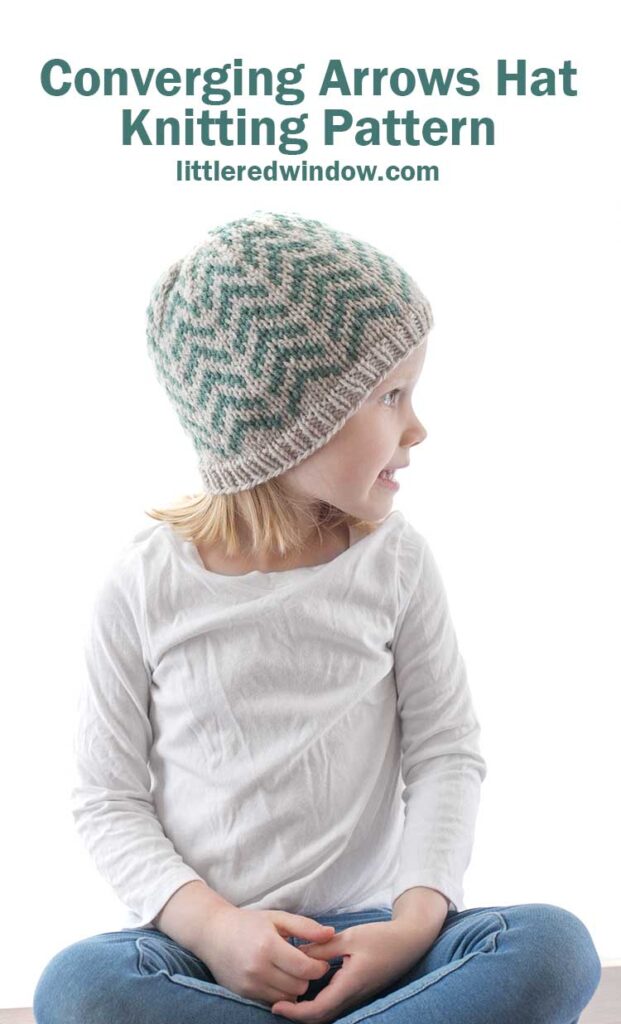 little girl looking off to right and wearing tan and teal coverging arrows hat knitting pattern