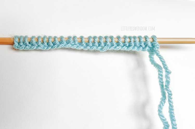 a knitting needle with light blue yarn showing the right side of the German twisted cast on method