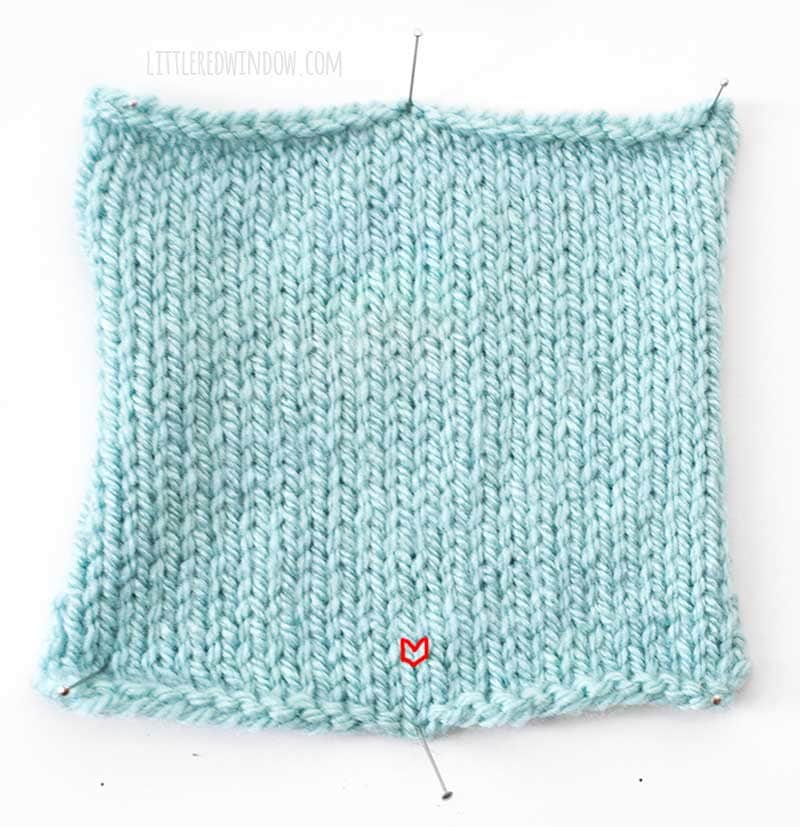 light blue swatch of stockinette stitch knitting with a single knit stitch outlined in red