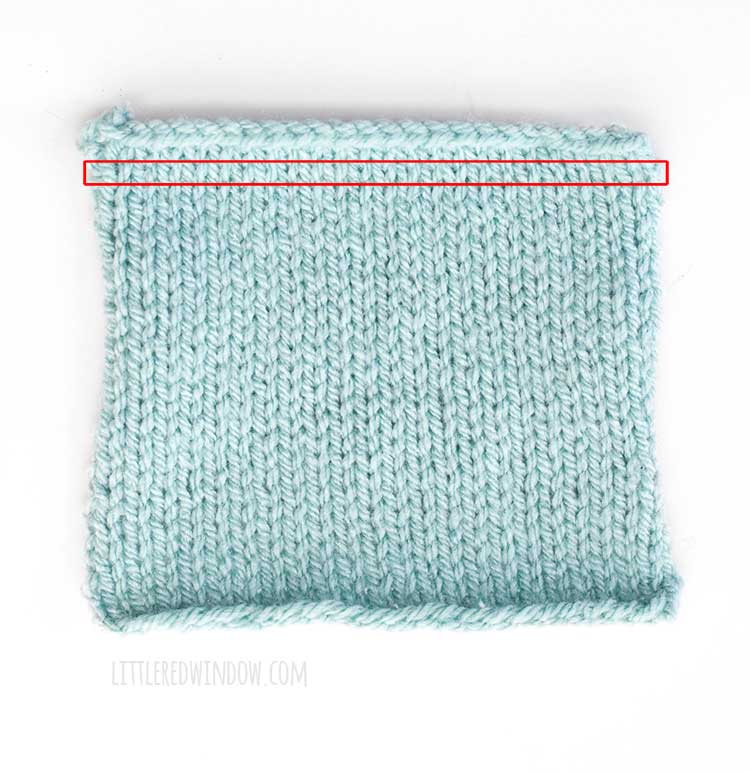light blue swatch of stockinette stitch knitting with a single row highlighted in red