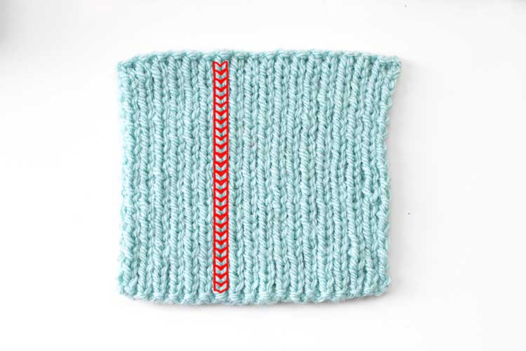 light blue square swatch of 1 by 1 ribbing  with one column of individual stitches outlined in red