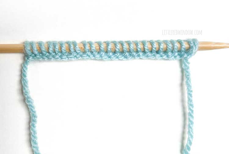 a knitting needle with light blue yarn showing the right side of the knitted cast on method
