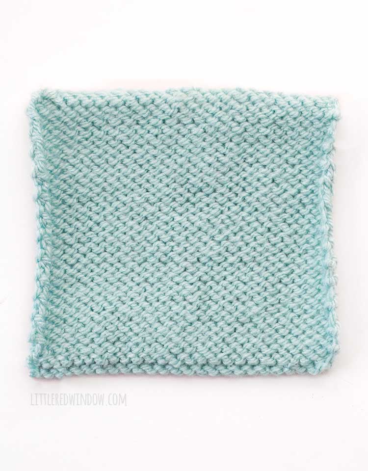 light blue square of stockinette stitch knitting showing the back wrong side of the fabric in front of a white background