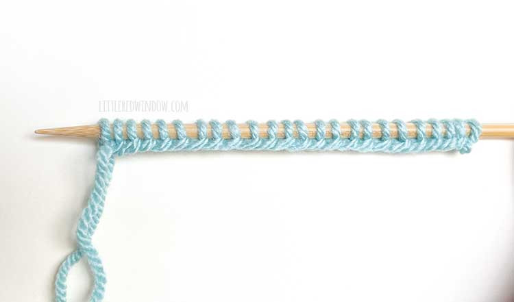 a knitting needle with light blue yarn showing the right side of the long tail cast on method