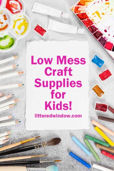 white table with mess colorful craft supplies pencils paint and paintbrushes around a piece of white paper that says low mess craft supplies for kids