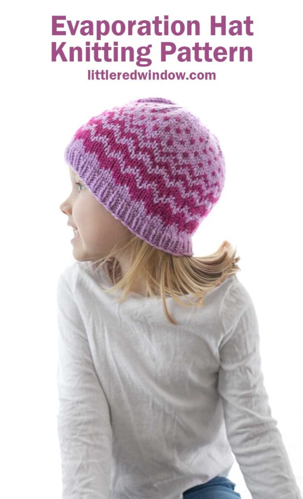 little girl in white shirt looking off to the left and wearing lavender knit hat with decreasing width zig zags in raspberry
