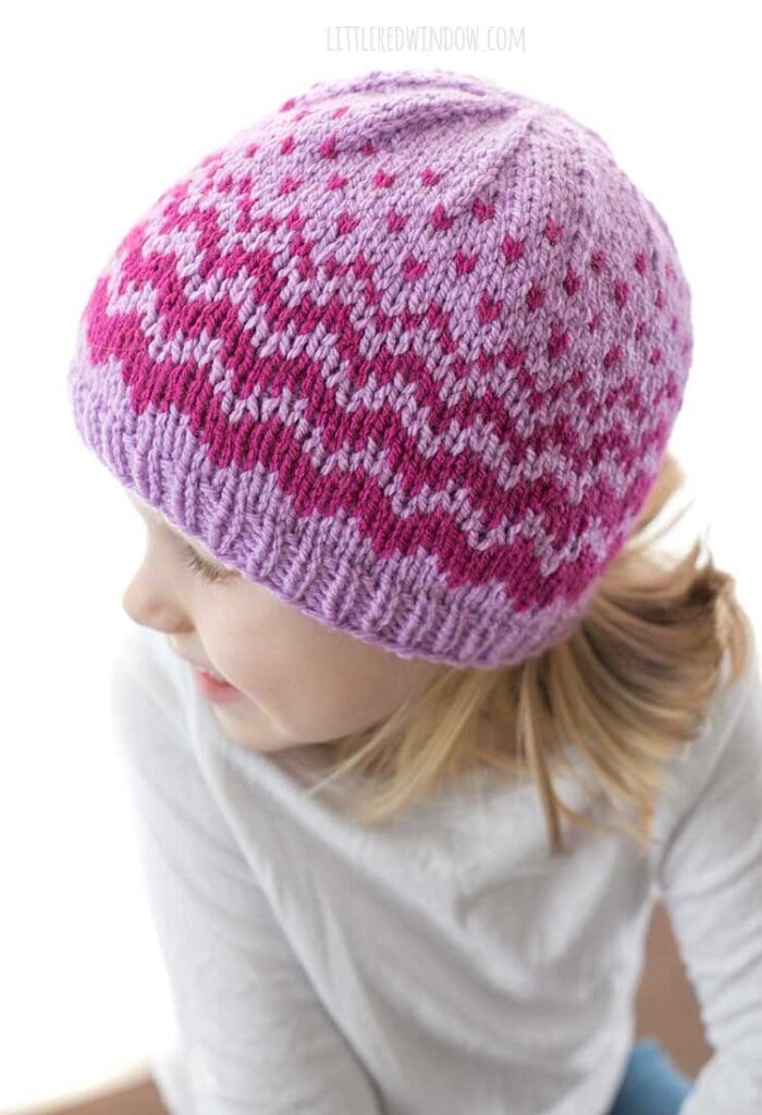 top view of evaporation hat knitting pattern on little girl in white shirt