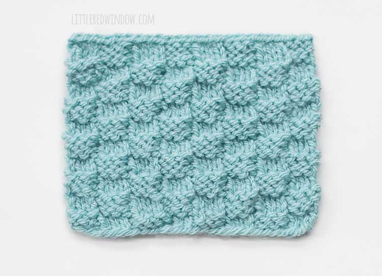 the front side of a light blue rectangle of basic checkerboard stitch knitting on a white background
