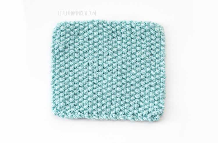 a light blue square swatch of the wrong side of seed stitch knitting on a white background