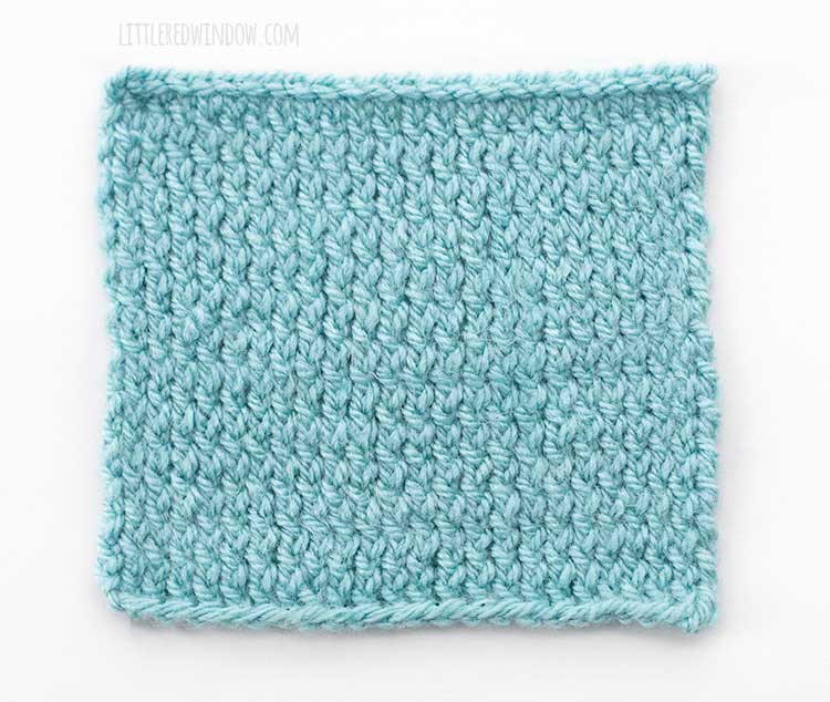 the right side of a light blue square of twisted stockinette stitch knitting on a white background