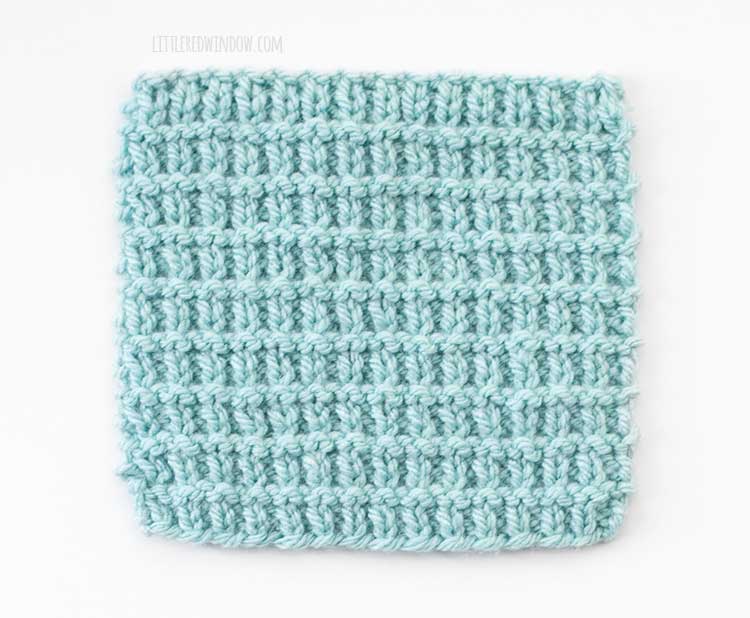 the right side of a light blue square swatch of broken rib stitch knitting on a white background