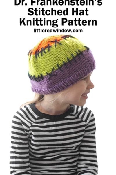 child in black and white striped shirt wearing a purple acid green and orange colorblocked knit hat with black stitching lines between the colors looking off to the right in front of a white background