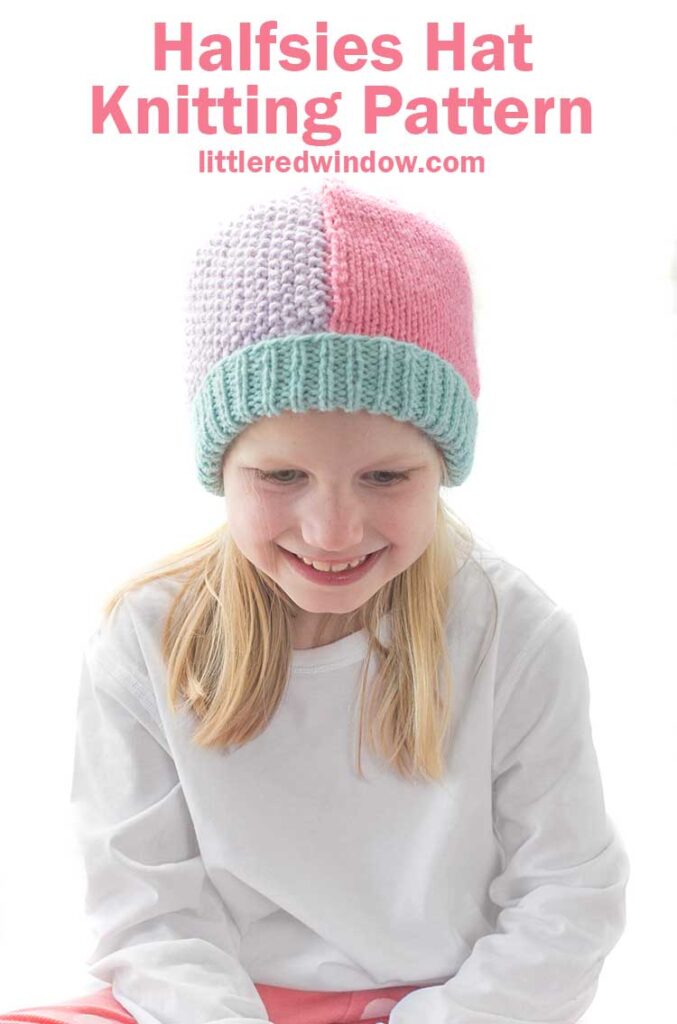 Smiling girl in white shirt and pink pants wearing a knit hat that has a light teal ribbed brim and is half pink stockinette stitch on the right and half light purple seed stitch on the left