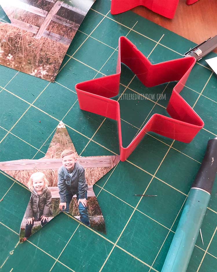 red star shaped cookie cutter sitting on a green cutting mat next to a star shaped photo of two kids and a green craft knife