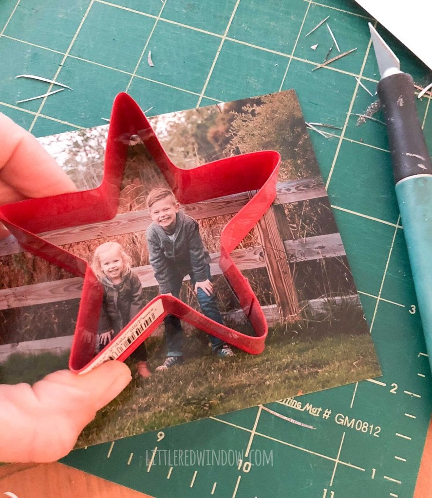 hand holding a red star shaped cookie cutter on top of a photo of two children