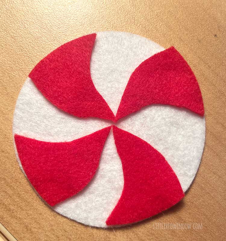 red and white felt peppermint candy shape on a wood background