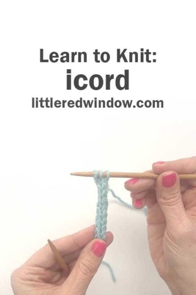 Two hands with pink nail polish hold wooden knitting needles, demonstrating how to knit an i-cord with light blue yarn. Text above reads: "Learn to Knit: icord littleredwindow.com".
