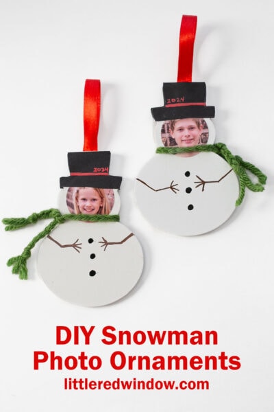 Two DIY snowman ornaments made from photos of children, each with a black hat, green yarn scarf, and red ribbon for hanging. The ornaments display the year "2024" on the hats. Text below reads "DIY Snowman Photo Ornaments.