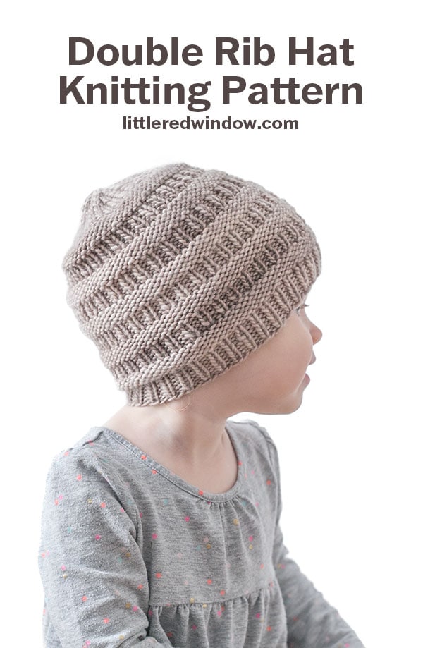 A young child wearing a gray Rib Hat with a double rib pattern looks to the side. Text above reads: “Double Rib Hat Knitting Pattern littleredwindow.com.” The child is in a gray shirt with small colored dots.