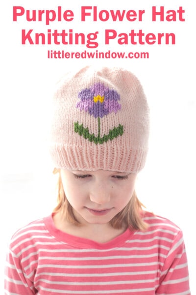 Young girl wearing a light pink flower hat with a purple flower and green leaves design, looking down. Text above reads: