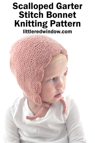 A young child wears a delicate, pink scalloped bonnet knitted in garter stitch. The text above reads: