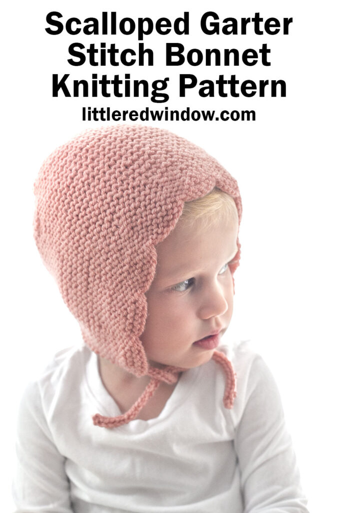 A young child wears a delicate, pink scalloped bonnet knitted in garter stitch. The text above reads: