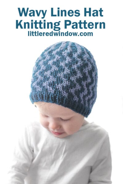A young child wearing a blue knitted hat featuring Wavy Lines, looking down. Text above reads